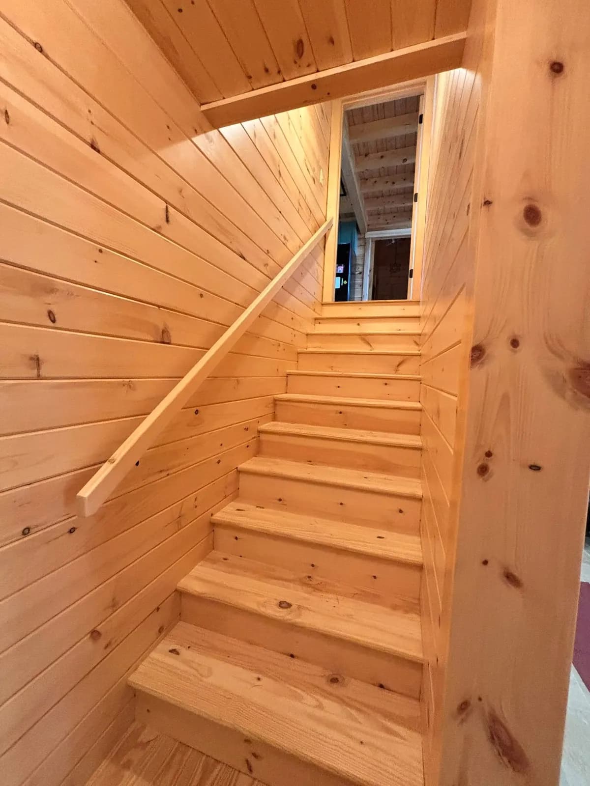 Pine staircase in a log chalet — Design/Build project in Lakes Region, NH by A&E Home Improvement